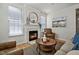 Comfortable living room with a fireplace, stylish decor, and plenty of natural light from large windows at 2000 Silky Dogwood Trail Trl, Apex, NC 27502