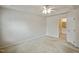 Spacious main bedroom with neutral carpet, ceiling fan, and adjoining bathroom entrance at 2000 Silky Dogwood Trail Trl, Apex, NC 27502
