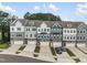An aerial view showcases modern townhomes with garages, surrounded by landscaped lawns at 2006 Leo Dr, Apex, NC 27502