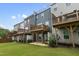 A row of townhomes with patios and decks overlooks a green backyard, perfect for outdoor enjoyment at 2006 Leo Dr, Apex, NC 27502