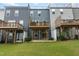Townhomes with patios and decks offer outdoor space in a well-maintained backyard with green grass at 2006 Leo Dr, Apex, NC 27502