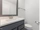 A well-lit powder room featuring a modern vanity with gray cabinets and a white countertop at 2006 Leo Dr, Apex, NC 27502
