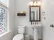 This bright, modern bathroom features a pedestal sink, decorative window, and contemporary fixtures at 2006 Leo Dr, Apex, NC 27502
