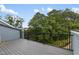 A wooden deck with black railings offers views of tall trees and blue skies at 2006 Leo Dr, Apex, NC 27502