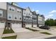 A row of modern townhomes with garages and colorful doors line the street at 2006 Leo Dr, Apex, NC 27502