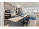 Bright open kitchen featuring stainless steel appliances, gray cabinets, a large island, and barstool seating at 2006 Leo Dr, Apex, NC 27502