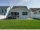 Back exterior view of a charming home with a screened-in porch and well-manicured lawn at 2013 Woodbluff Dr, Wendell, NC 27591