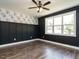 This bedroom has black and white wallpaper, gray walls, hardwood floors, and a ceiling fan with light at 2013 Woodbluff Dr, Wendell, NC 27591