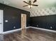This bedroom has hardwood floors, gray walls, black and white wallpaper, and a door to the bathroom at 2013 Woodbluff Dr, Wendell, NC 27591
