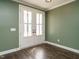 This home showcases a pair of white doors, dark wooden floors, light trim, and muted green walls at 2013 Woodbluff Dr, Wendell, NC 27591