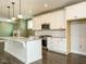 This kitchen has white cabinets, stainless steel appliances, dark floors, and a large island at 2013 Woodbluff Dr, Wendell, NC 27591