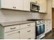 A modern kitchen features stainless steel appliances, white cabinetry, granite counters, and dark hardwood floors at 2013 Woodbluff Dr, Wendell, NC 27591