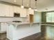 Bright kitchen featuring a large island, modern pendant lighting, stainless steel appliances, and green accent walls at 2013 Woodbluff Dr, Wendell, NC 27591