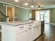 An open kitchen with a white island with a sink, stainless steel appliances, and muted green walls at 2013 Woodbluff Dr, Wendell, NC 27591