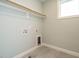Bright laundry area featuring tile floor, utility connections and white shelves ready for organizing at 2013 Woodbluff Dr, Wendell, NC 27591