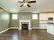 Open-concept living area showcasing a fireplace with brick surround, hardwood floors, and easy access to the kitchen at 2013 Woodbluff Dr, Wendell, NC 27591