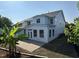 Back exterior of the home with a gray roof, blue siding, a patio, and tropical landscaping at 205 Bog Hill Ln, Cary, NC 27519