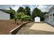 Large backyard featuring a storage shed, brick paver patio, mature trees, and white fence at 205 Bog Hill Ln, Cary, NC 27519