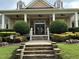 Clubhouse entryway with double doors flanked by manicured bushes and stone steps at 205 Bog Hill Ln, Cary, NC 27519