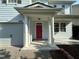 Covered front porch featuring white columns and a vibrant pink front door with a patterned concrete walkway at 205 Bog Hill Ln, Cary, NC 27519
