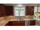 Well-lit kitchen featuring granite countertops, stainless steel appliances, and dark wood cabinets at 205 Bog Hill Ln, Cary, NC 27519