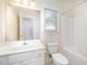 Bright bathroom with a large mirror, white vanity, toilet, and a shower/tub combo with neutral decor at 209 Homegate Cir, Apex, NC 27502