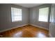 Bright bedroom with hardwood floors and natural light from two windows at 2100 Breeze Rd, Raleigh, NC 27608