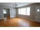 Bright living room with gleaming hardwood floors and large window at 2100 Breeze Rd, Raleigh, NC 27608