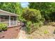Inviting backyard deck and garden featuring established trees, flowerbeds and privacy at 211 Hills Of The Haw Rd, Pittsboro, NC 27312