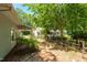 Charming backyard featuring mature trees, lush landscaping, and a partial fence at 211 Hills Of The Haw Rd, Pittsboro, NC 27312
