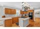 Functional kitchen with wooden cabinets, modern appliances, and a center island offers ample space for cooking at 211 Hills Of The Haw Rd, Pittsboro, NC 27312