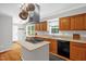 A kitchen featuring wood cabinets, stainless steel appliances, a gas cooktop and hardwood floors at 211 Hills Of The Haw Rd, Pittsboro, NC 27312