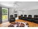 Well-lit living room featuring a fireplace, hardwood floors, and comfortable seating provides a cozy space at 211 Hills Of The Haw Rd, Pittsboro, NC 27312