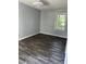 This bedroom features gray walls, hardwood flooring, and a window at 2116 Tanglewood Rd, Rocky Mount, NC 27804