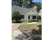 Inviting one-story home with gray roof, featuring a charming front porch and lush landscaping at 2116 Tanglewood Rd, Rocky Mount, NC 27804