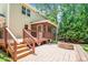 An exterior view of a home features a stone patio and wooden deck, ideal for outdoor entertaining at 212 Heidinger Dr, Cary, NC 27511