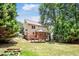 Landscaped backyard with a screened porch, wooden deck, and wooded perimeter at 212 Heidinger Dr, Cary, NC 27511