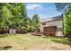 A backyard has a fire pit, wood deck and storage shed surrounded by mature trees at 212 Heidinger Dr, Cary, NC 27511
