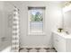 Bright bathroom features window, white vanity, cabinet storage, and shower with curtain at 212 Heidinger Dr, Cary, NC 27511