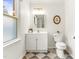 Clean bathroom with window features a vanity with cabinet, toilet, and checkered floors at 212 Heidinger Dr, Cary, NC 27511