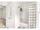 Clean bathroom showcasing a shower-tub with a patterned curtain and checkered flooring near an open door at 212 Heidinger Dr, Cary, NC 27511