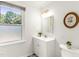 Bright bathroom with window has a white vanity and cabinet for storage at 212 Heidinger Dr, Cary, NC 27511