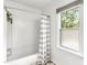 Bright bathroom featuring a shower-tub combo with striped curtain and a window providing natural light at 212 Heidinger Dr, Cary, NC 27511