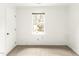 A simply designed bedroom featuring neutral carpet, white walls, a window, and a door at 212 Heidinger Dr, Cary, NC 27511