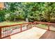 A wooden deck features railing overlooking a lush green backyard with an stone fire pit and seating area at 212 Heidinger Dr, Cary, NC 27511