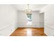 Bright dining room featuring hardwood floors, a gold chandelier, wainscotting, and views to the outside at 212 Heidinger Dr, Cary, NC 27511