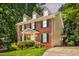 Charming two-story brick home with green shutters and lush landscaping at 212 Heidinger Dr, Cary, NC 27511