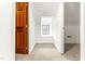 Hallway with natural wood door leading to another room with a window at 212 Heidinger Dr, Cary, NC 27511