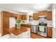 Remodeled kitchen featuring an island with seating, stainless steel appliances, wood cabinets, and white countertops at 212 Heidinger Dr, Cary, NC 27511