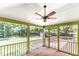 An enclosed back porch featuring a ceiling fan, wood floors and views of the lush greenery in the back yard at 212 Heidinger Dr, Cary, NC 27511